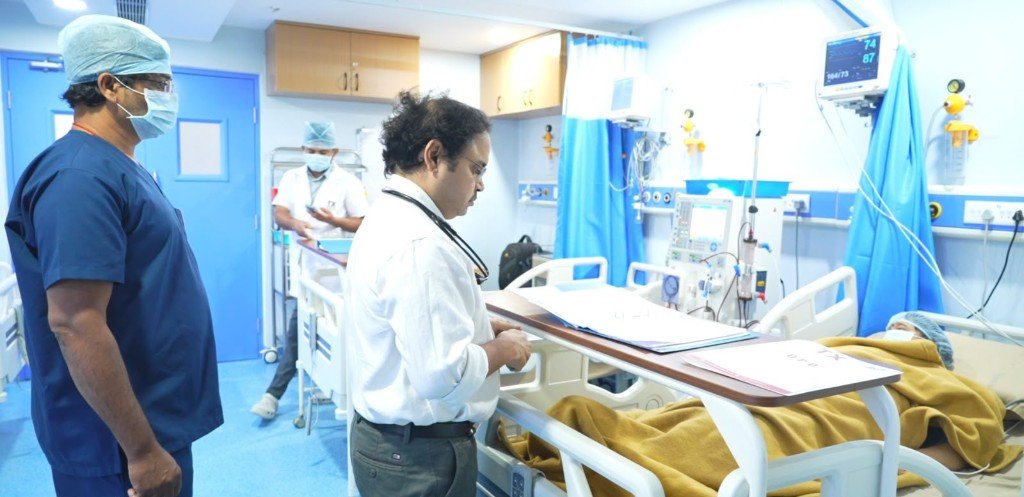 Medical team with doctor reviewing charts near a patient